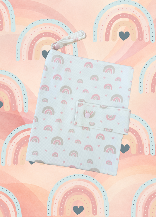 Porta pannolini neonato fatto a mano in cotone con arcobaleni rosa e tortora, chiusura con bottone a pressione rosa.